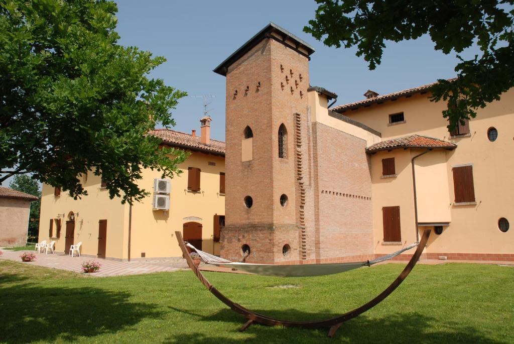 un edificio con torre dell'orologio e amaca in un cortile di Agriturismo Flabeto a Budrio