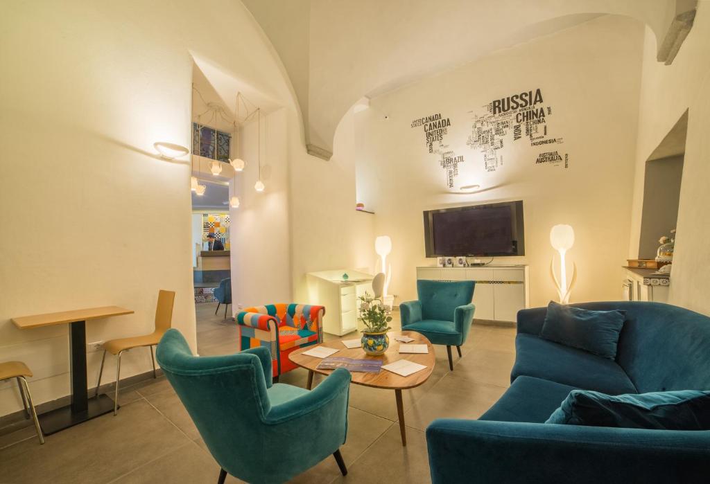 sala de estar con sillas azules y mesa en Airone Hotel, en Nápoles