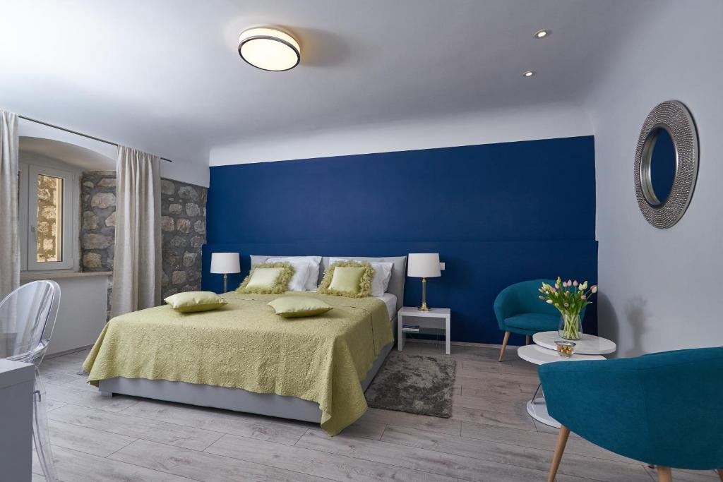 Dormitorio azul con cama y pared azul en Apartments Giron, en Dubrovnik