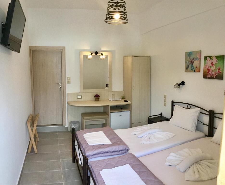 2 łóżka pojedyncze w pokoju z kuchnią w obiekcie Platanos Rooms w mieście Sinoikismós Kámbos