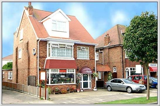 a house with a car parked in front of it at Savona Hotel in Skegness