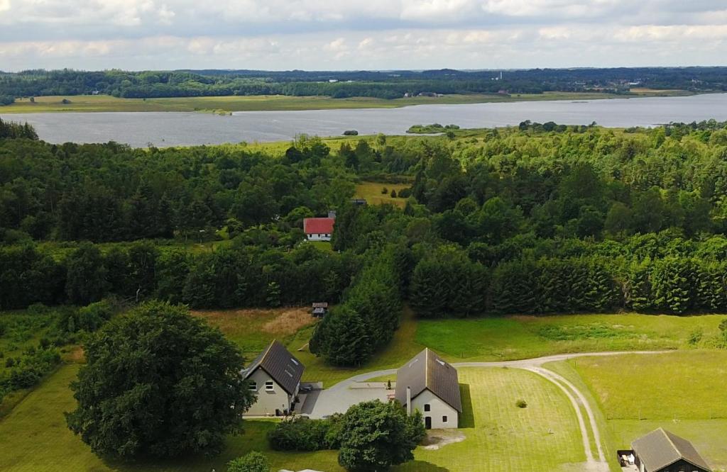 an aerial view of a house on a field next to a lake at Bøllingsø Feriehus in Silkeborg