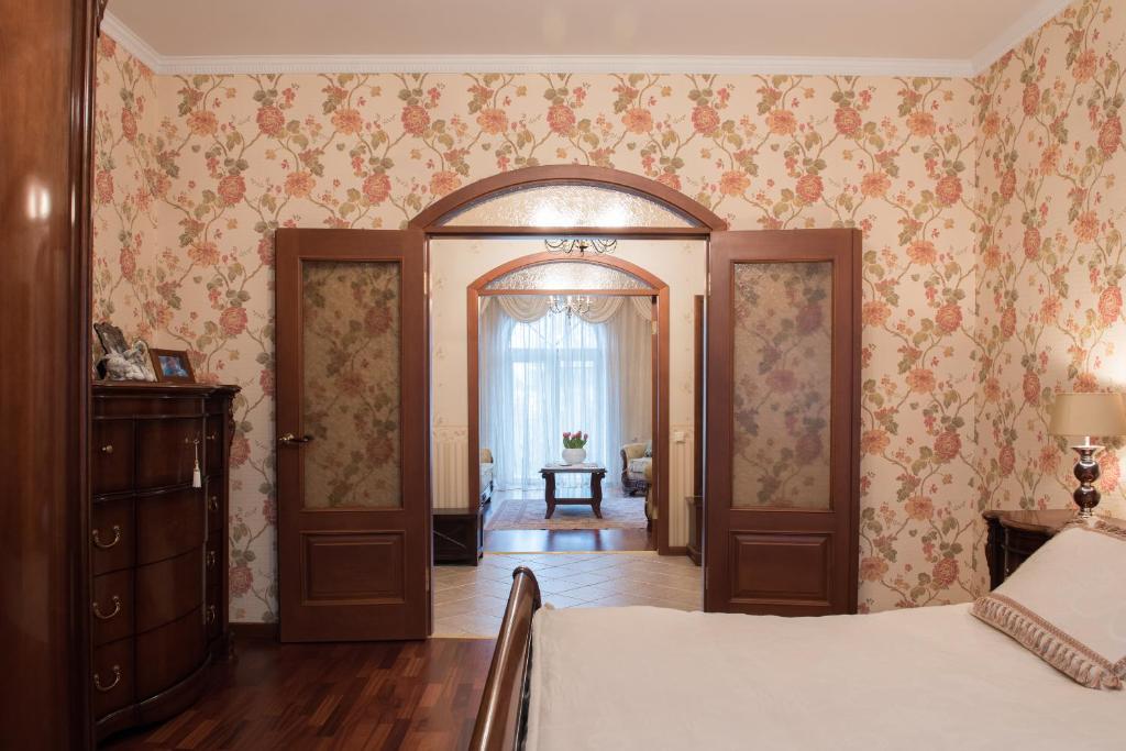 a bedroom with a bed and a hallway with wallpaper at Classy apartment in good neighbourhood in Riga