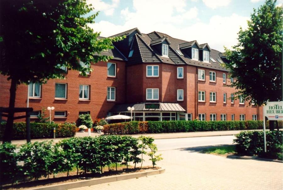 un gran edificio de ladrillo rojo con muchas ventanas en Hotel Heuberg en Norderstedt