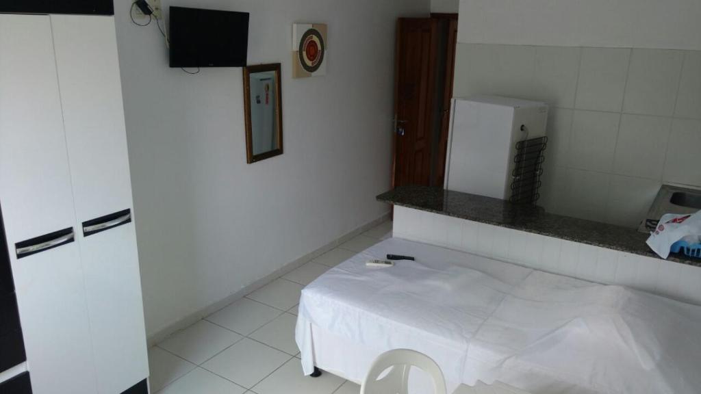 a white room with a white bed and a counter at Residencial Dom Fernando in Belém