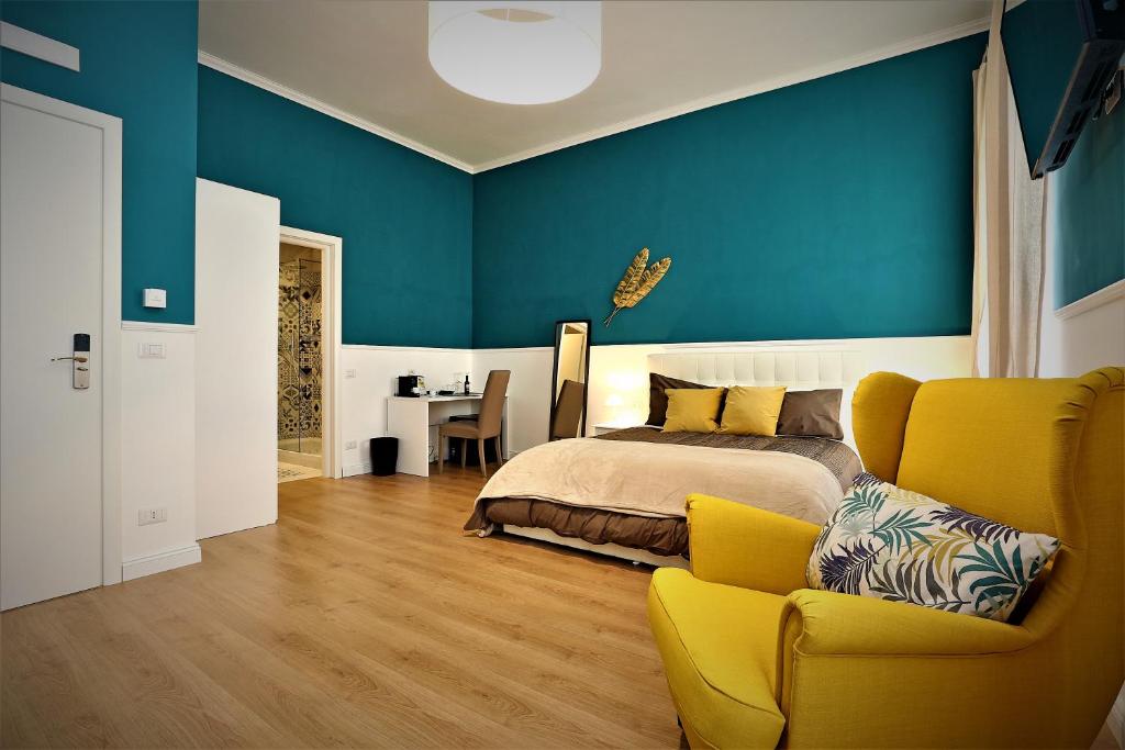 a bedroom with a bed and a yellow chair at romantica guest house in Rome