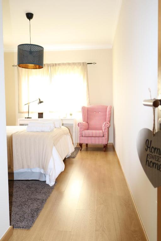 a bedroom with a bed and a chair and a window at Loulé Charming in Loulé