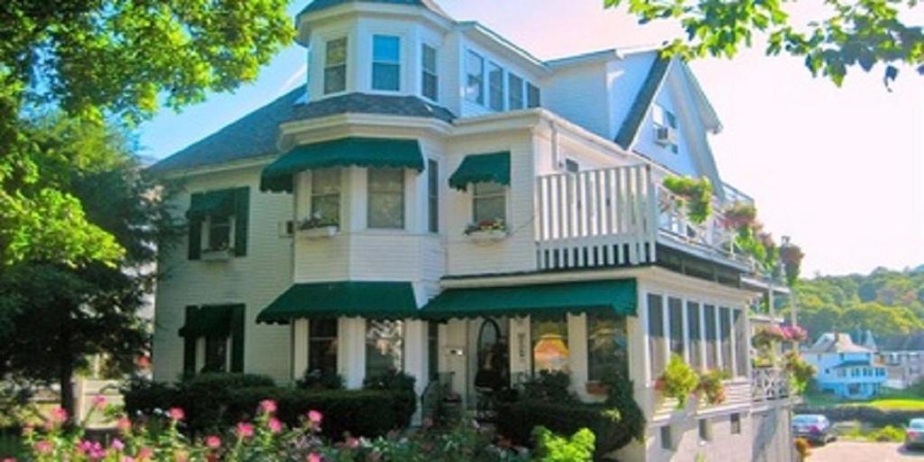 a large house with a porch and a balcony at Harbour Towne Inn on the Waterfront in Boothbay Harbor