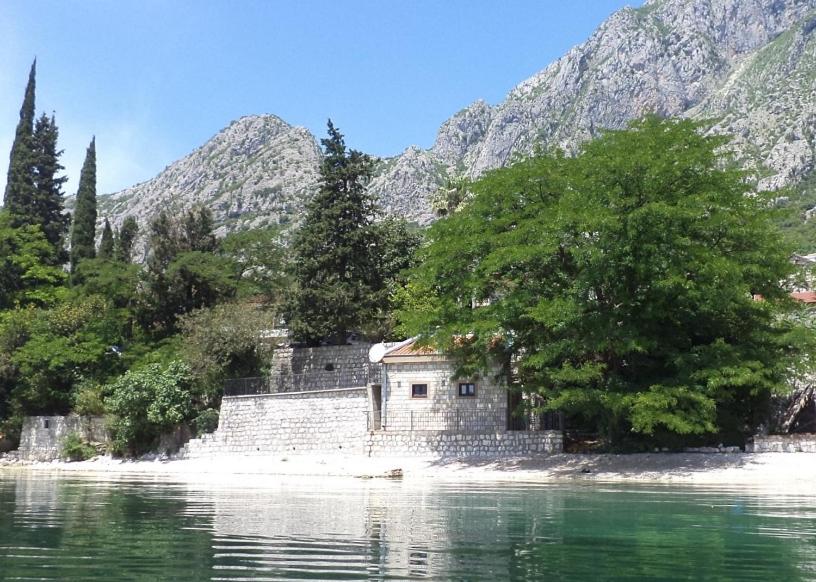 a building on the shore of a body of water at House on the beach in Kotor