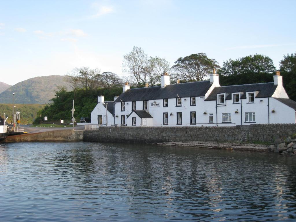 una casa blanca junto a un cuerpo de agua en Inn at Ardgour en Onich