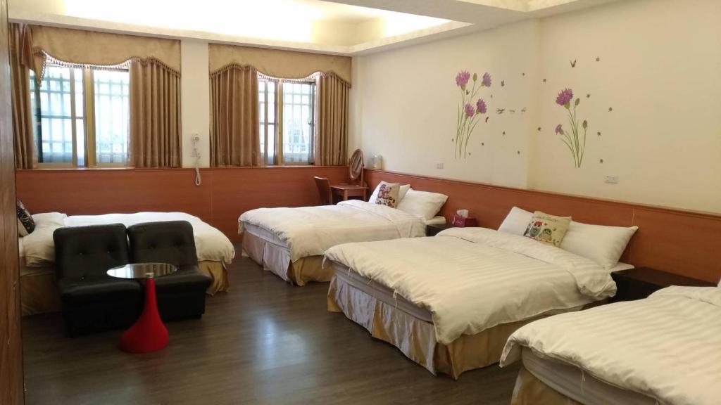 a hotel room with three beds and a table at Lianhangiu Homestay in Taitung City