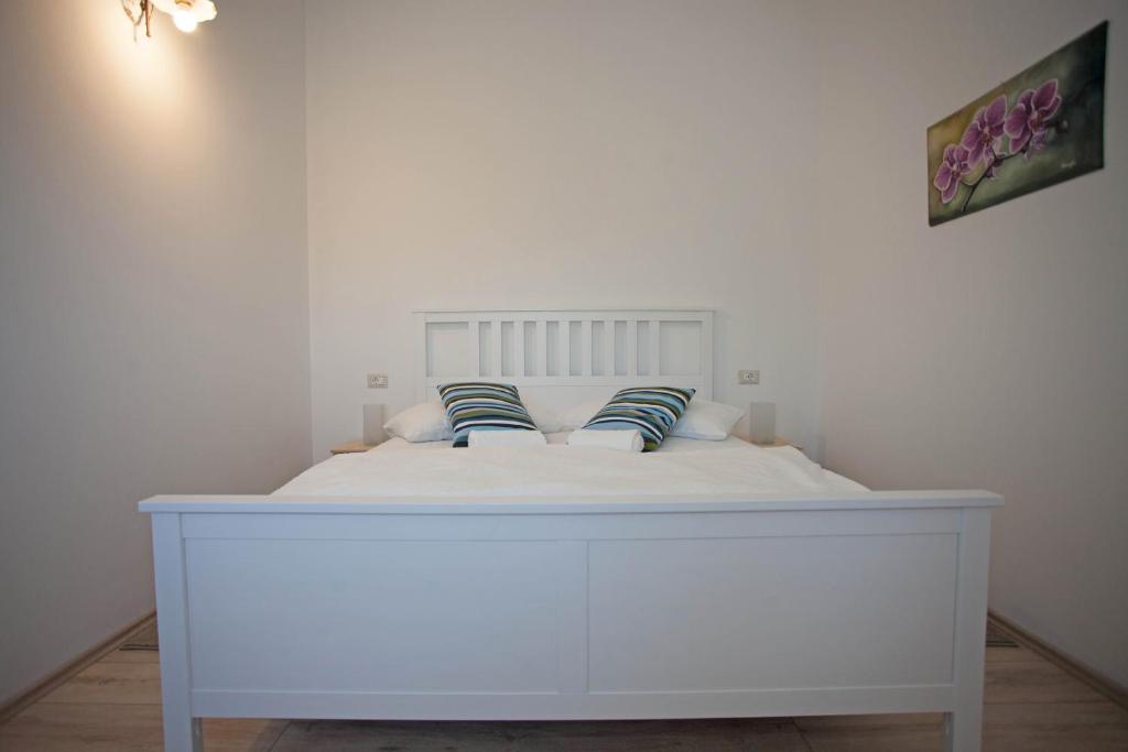 a white bed with two pillows on top of it at Residence Mama in Rovinjsko Selo