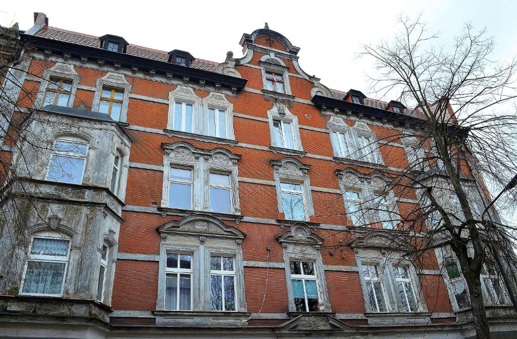 瓦烏布日赫的住宿－ART mieszkanie blisko dworca PKP Walbrzych Miasto，大型红砖建筑,设有白色窗户