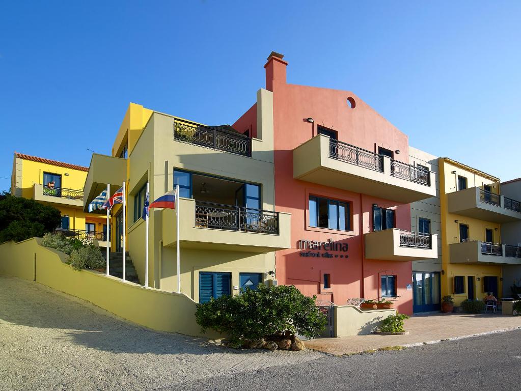 a multicolored building with balconies on a street at Marelina Villas in Panormos Rethymno