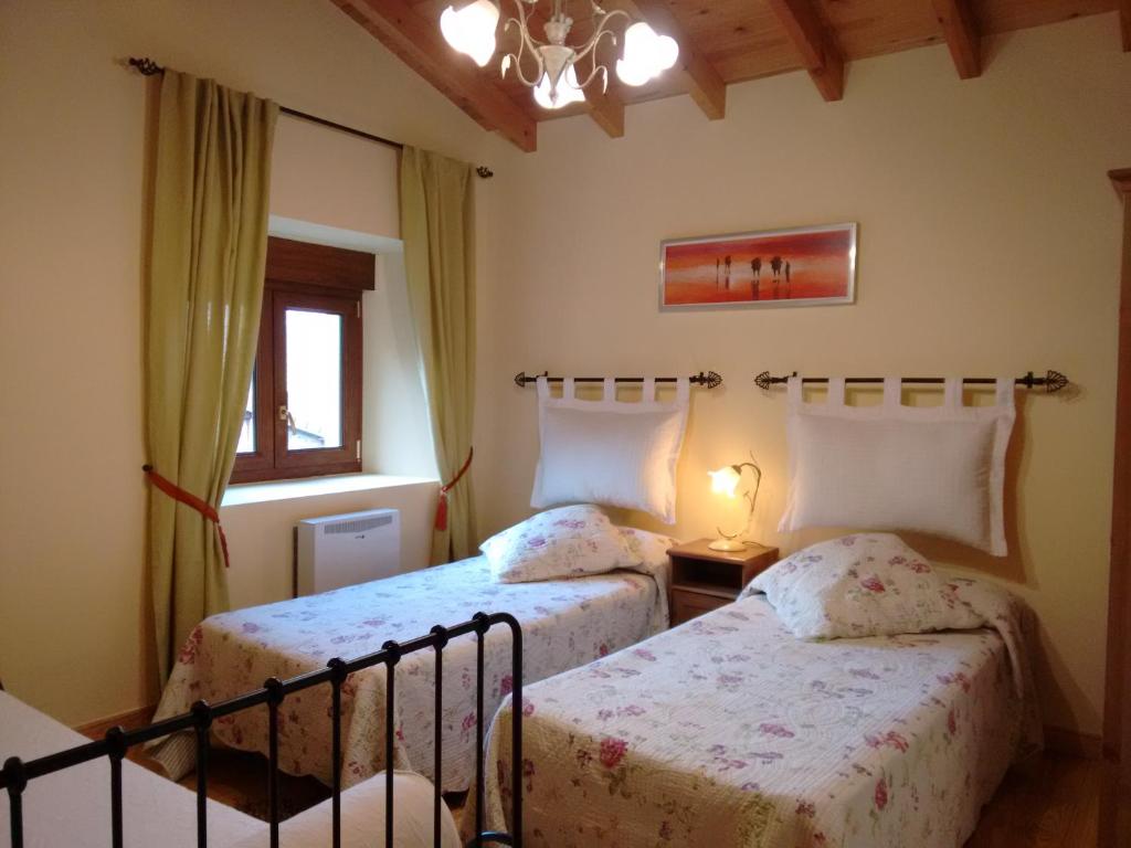 1 dormitorio con 2 camas y ventana en Casa Lindelagua, en Pámanes