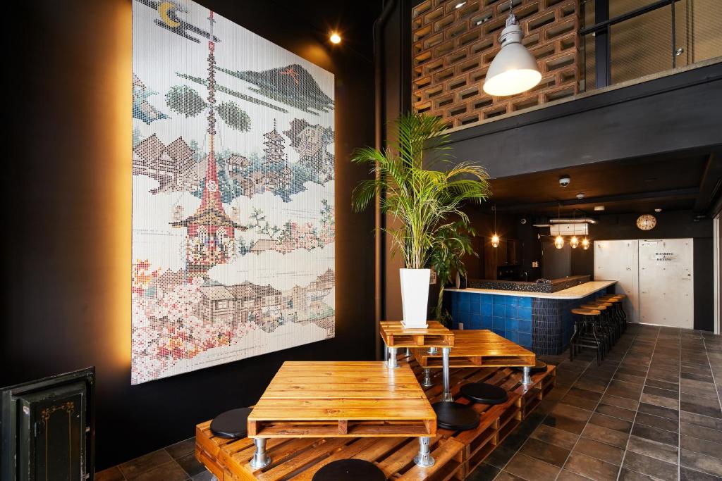 un ristorante con tavoli in legno e un'ampia immagine appesa al muro di Ya Do! KYOTO OKAZAKI a Kyoto