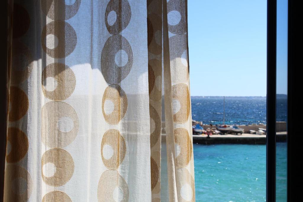 a window with a view of the ocean and a pool at Cala Dogana Guest House in Levanzo