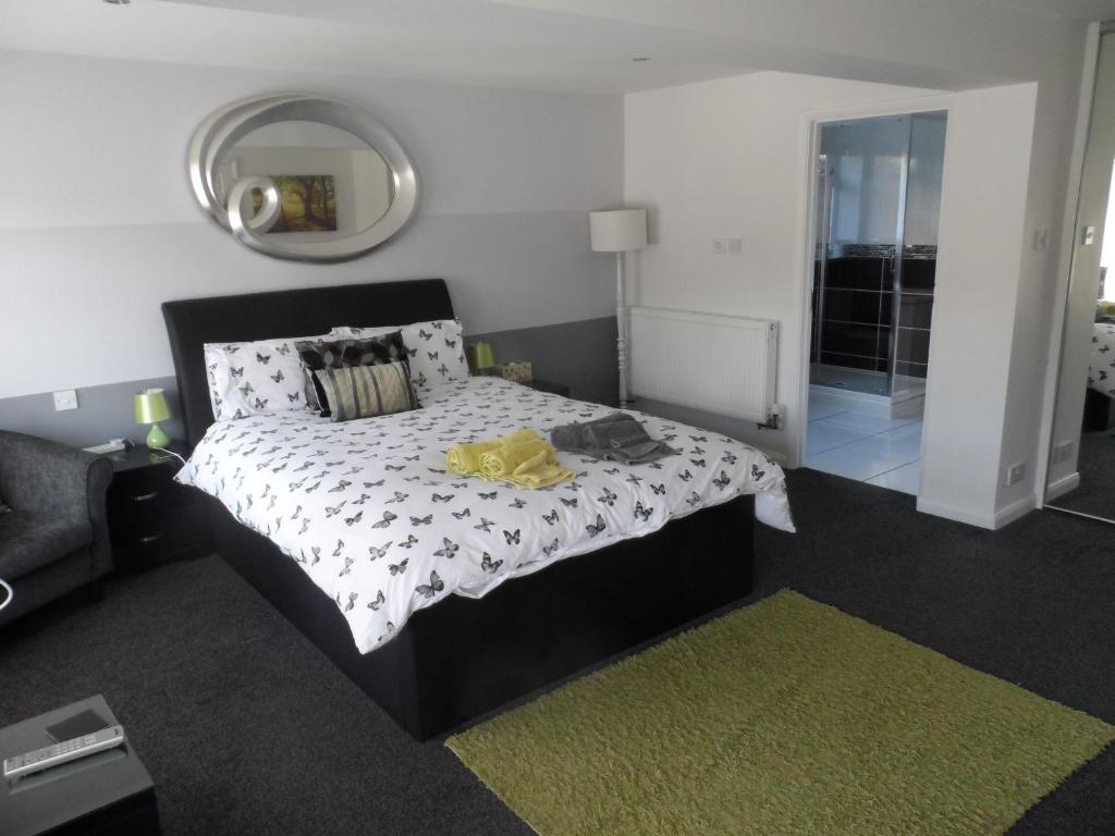 a bedroom with a black and white bed and a mirror at Mayfields Guest House in Wokingham