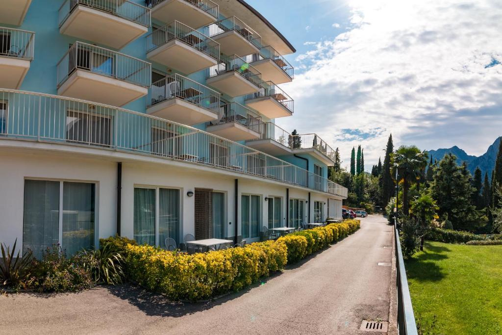 un edificio con balcones y flores en una calle en Residence Marina, en Riva del Garda