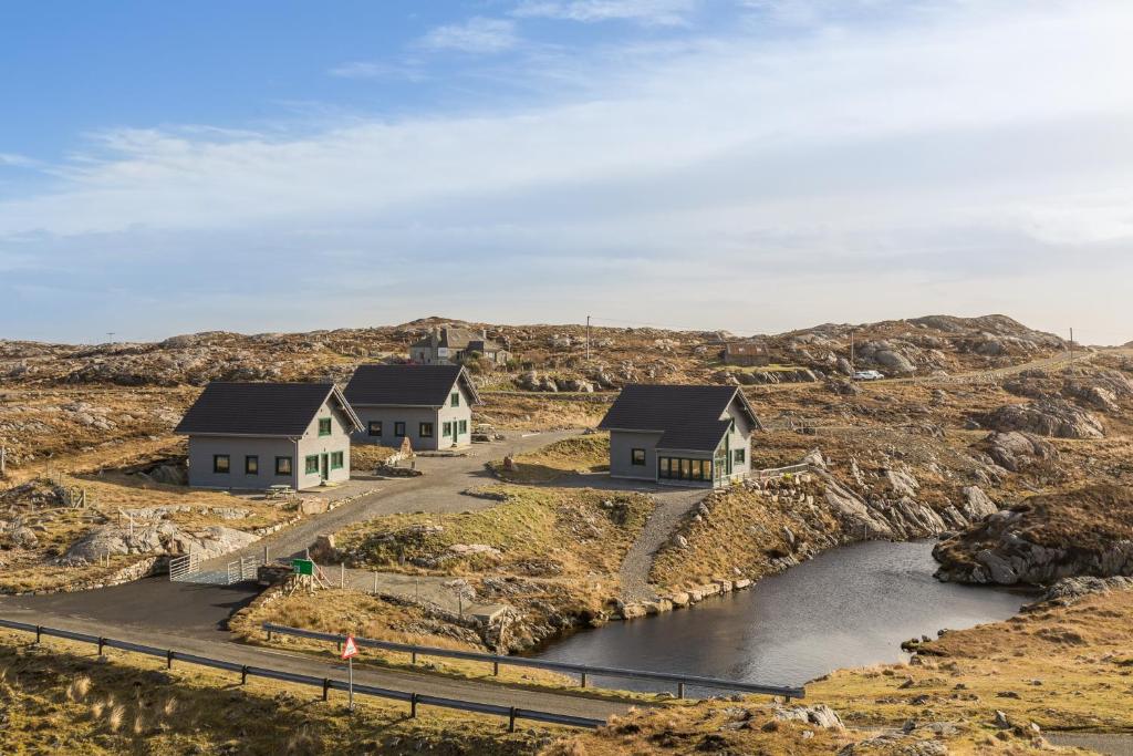 Coll Lodge, Isle of Harris في Manish: مجموعة منازل على تلة مع نهر