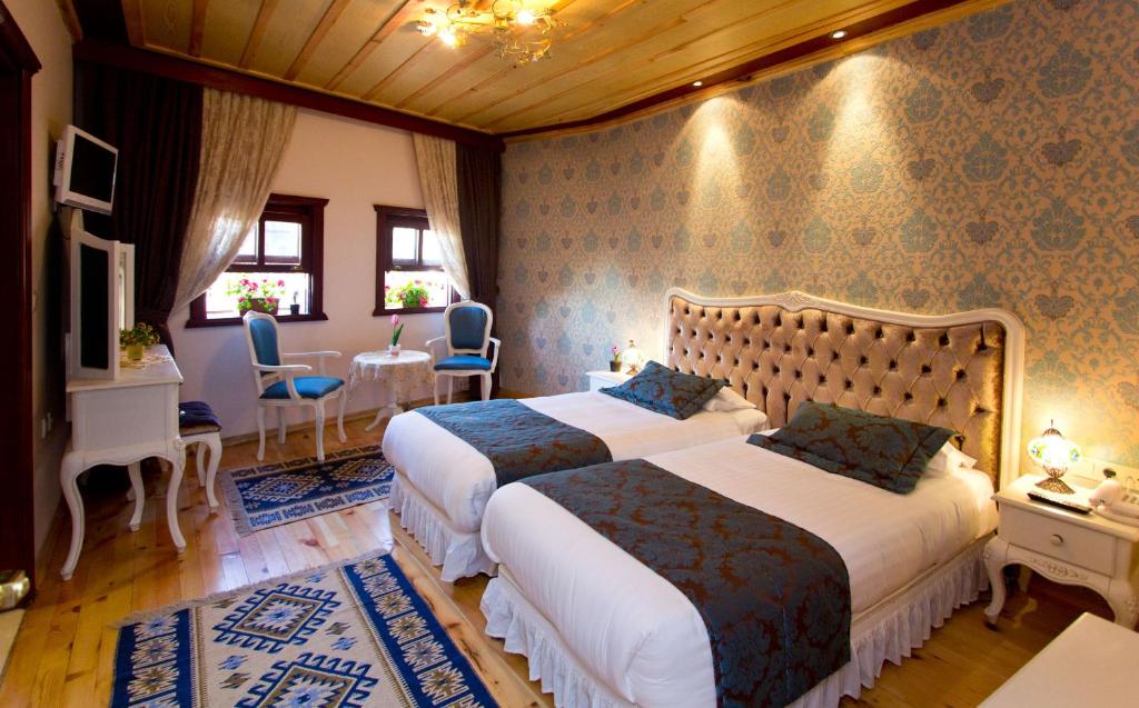 a bedroom with two beds and a table and chairs at Esans Hotel - Special Category in Istanbul