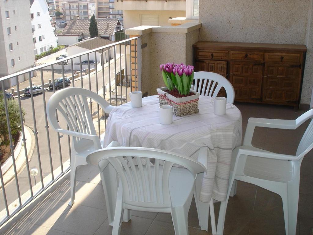 ロザスにあるDELTA 5º2ªの白いテーブル(白い椅子付)、バルコニー(花付)