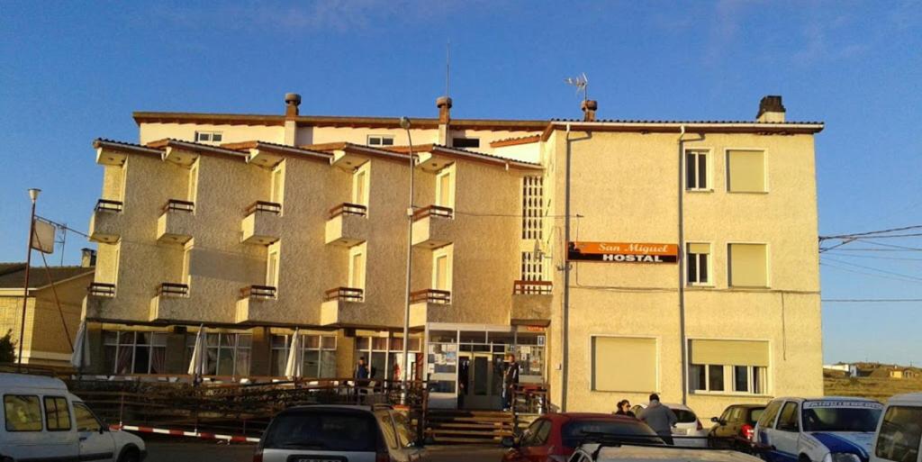 un gran edificio con coches estacionados frente a él en Hostal San Miguel, en León