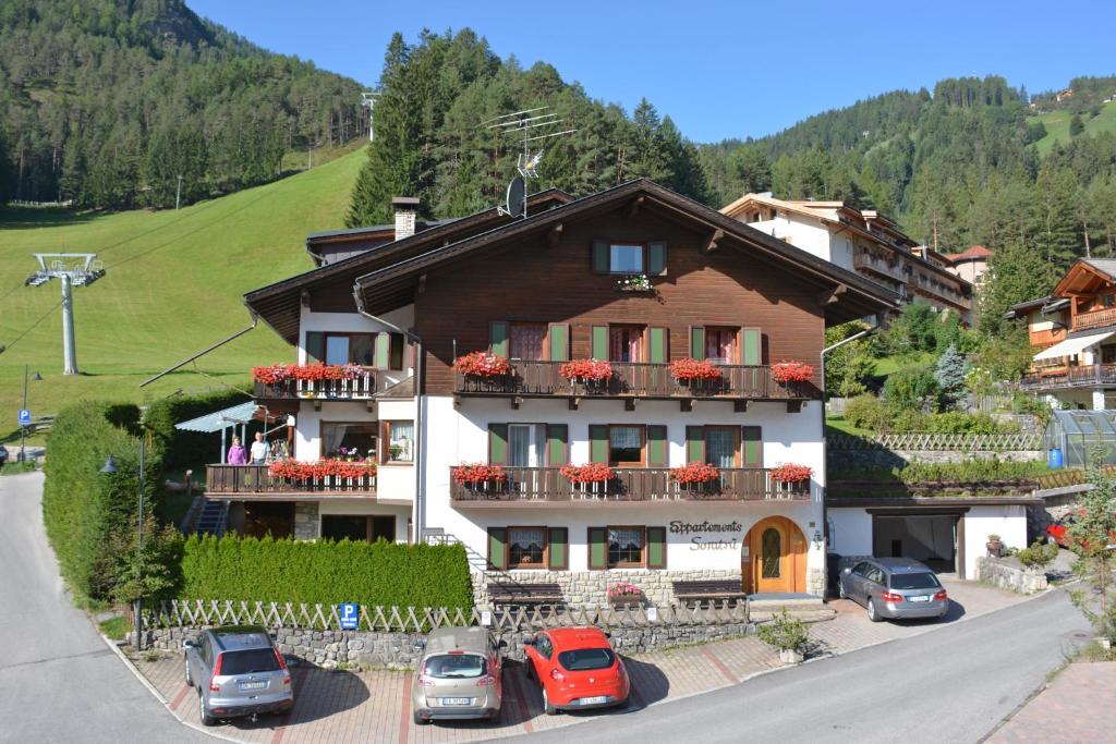 a large house with cars parked in front of it at Residence Soratru in San Vigilio Di Marebbe