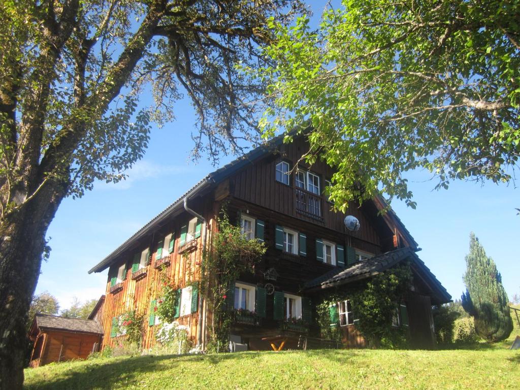 une grande maison avec un toit noir dans l'établissement Ferienwohnung Rehkoglgut, à Bad Goisern