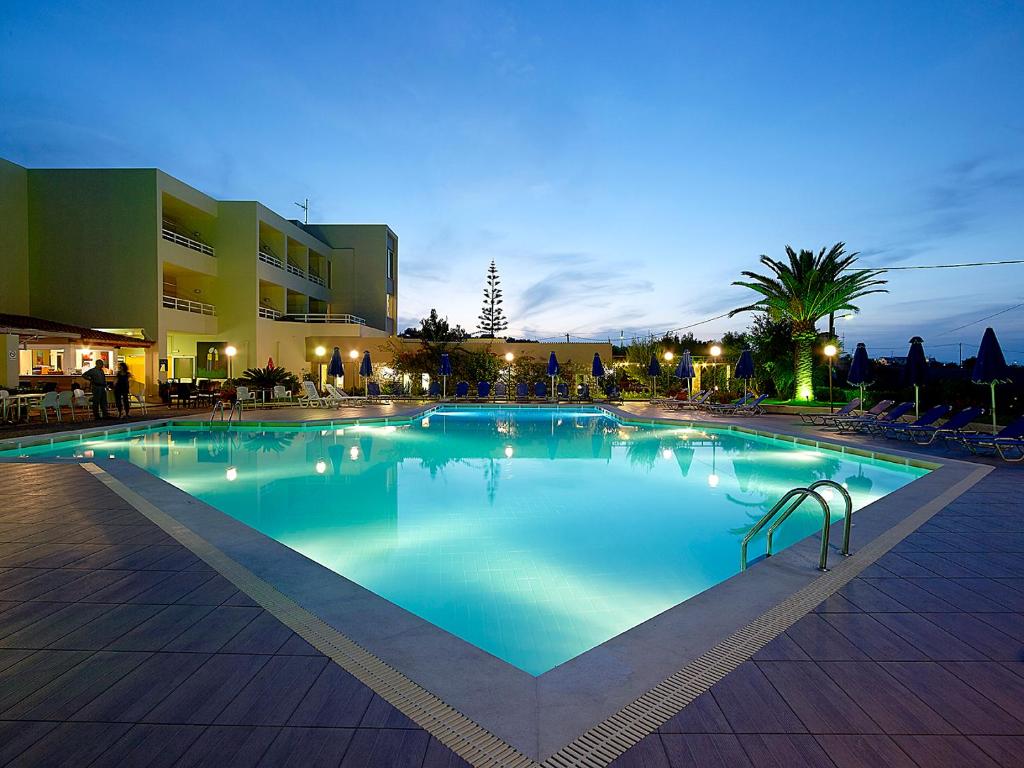 a large swimming pool at a hotel at night at Eleftheria Hotel in Agia Marina Nea Kydonias