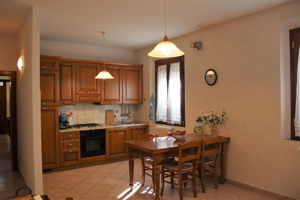cocina con armarios de madera y mesa de madera en Via di Roma 4, en Rávena