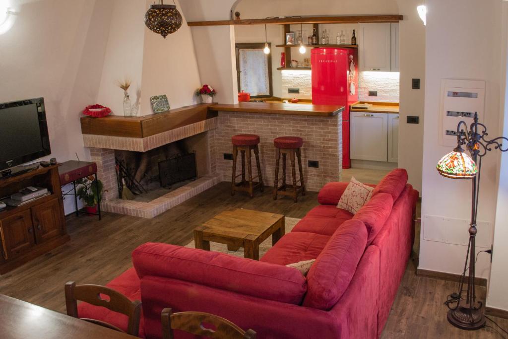 San GregorioにあるVilla Jades Sardiniaのリビングルーム(赤いソファ、暖炉付)