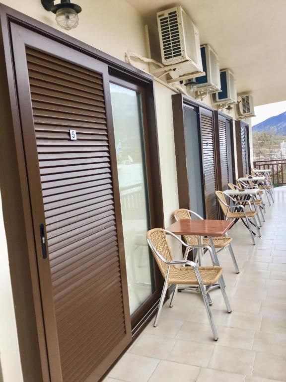 a row of chairs and tables on a balcony at Platanos Rooms in Anopoli Sfakion