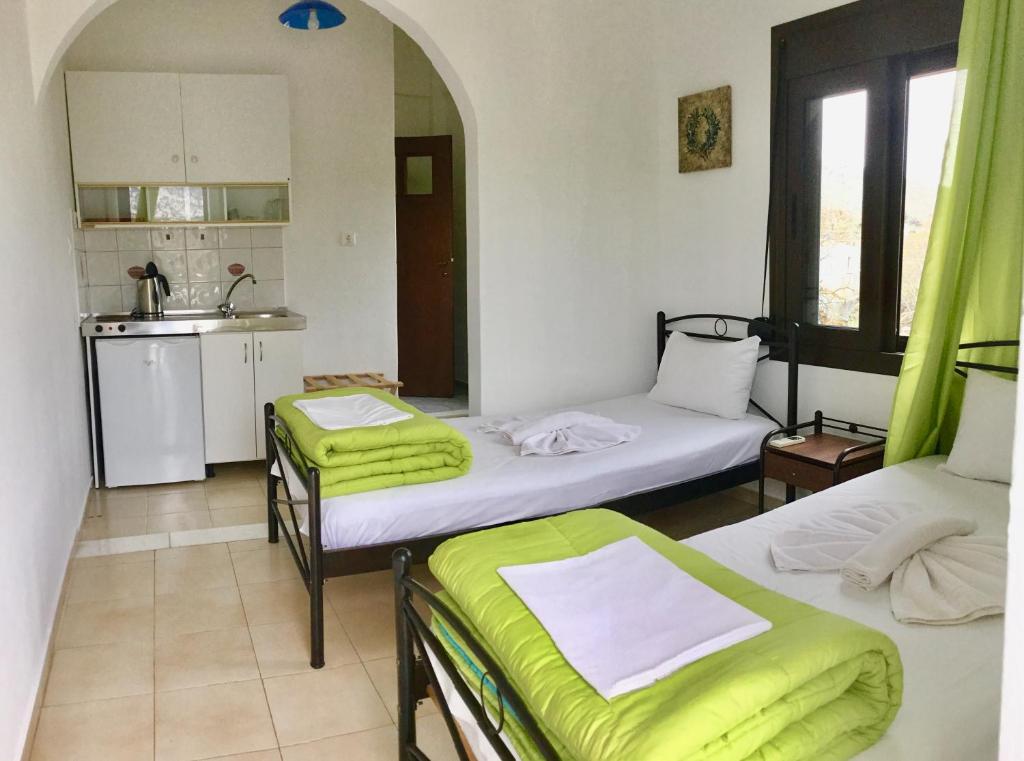 a room with two beds and a kitchen with a sink at Platanos Rooms in Anopoli Sfakion