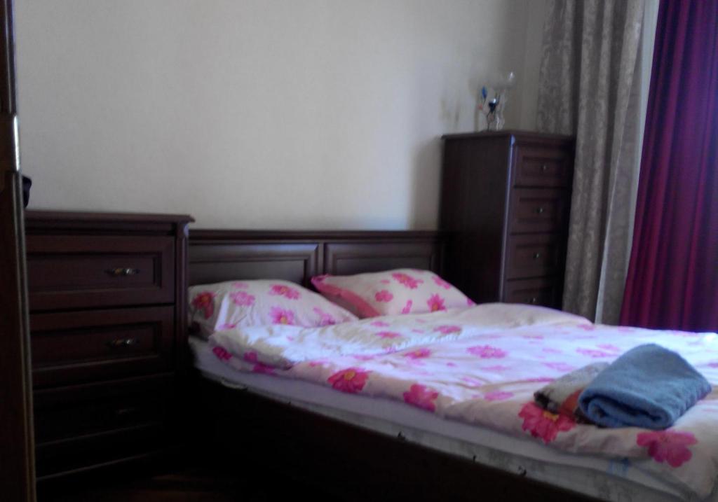 a bedroom with a bed and a dresser at Comfortable flat near the Dnieper river in Kyiv in Kyiv