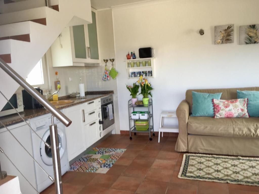 a kitchen and a living room with a couch at Casa Azul in Almograve