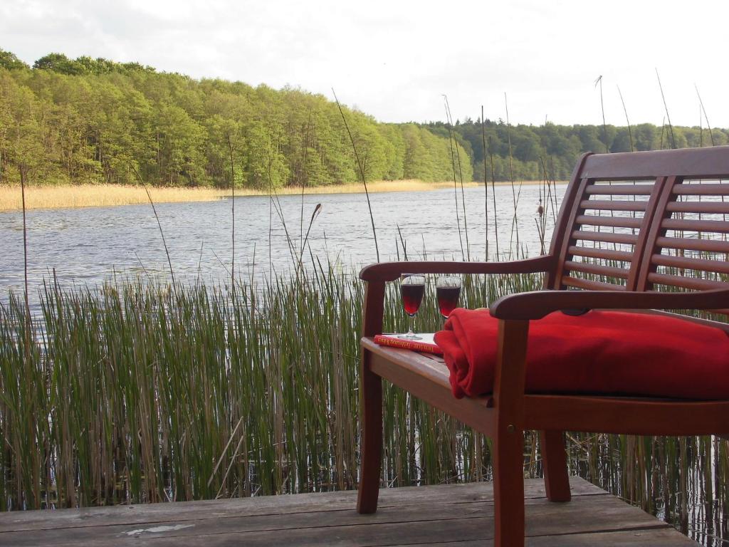 a chair sitting on a dock near a body of water at Försterhaus am Linowsee in Rheinsberg
