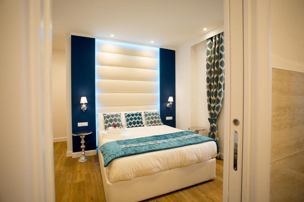 1 dormitorio con 1 cama con pared azul en Atmosfere Guest House - Cinque Terre e La Spezia en La Spezia
