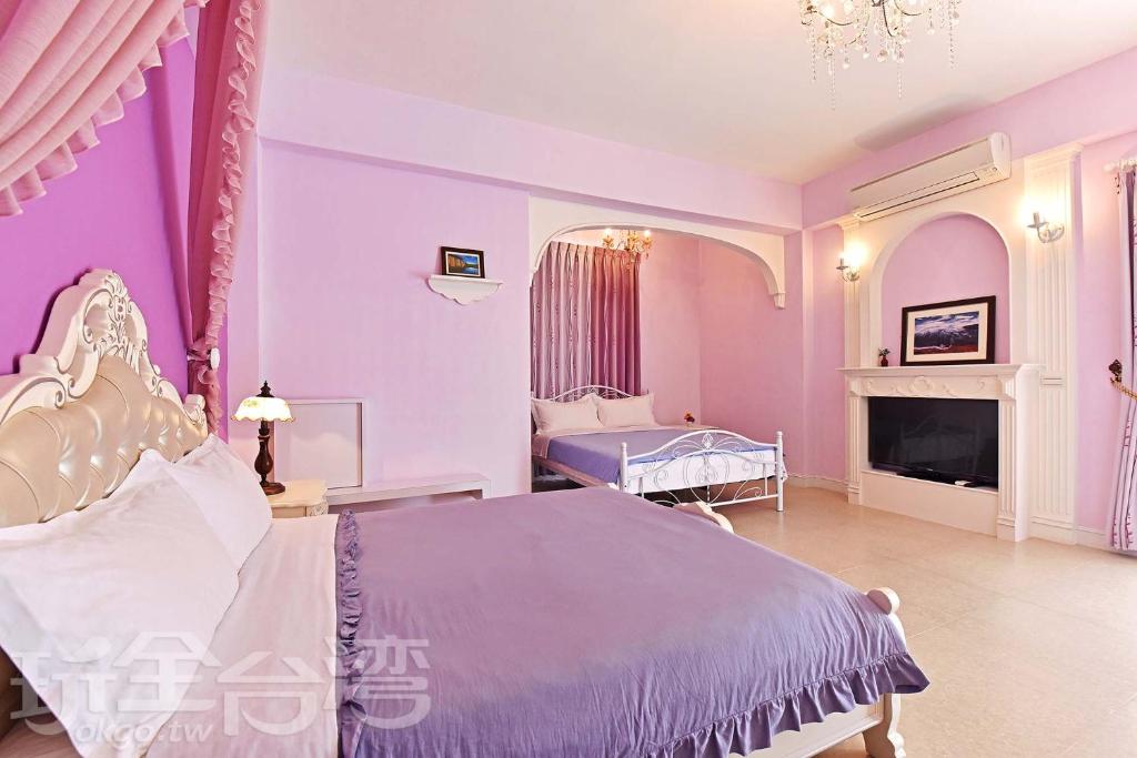 a purple bedroom with a bed and a fireplace at Love 3 cubed in Magong
