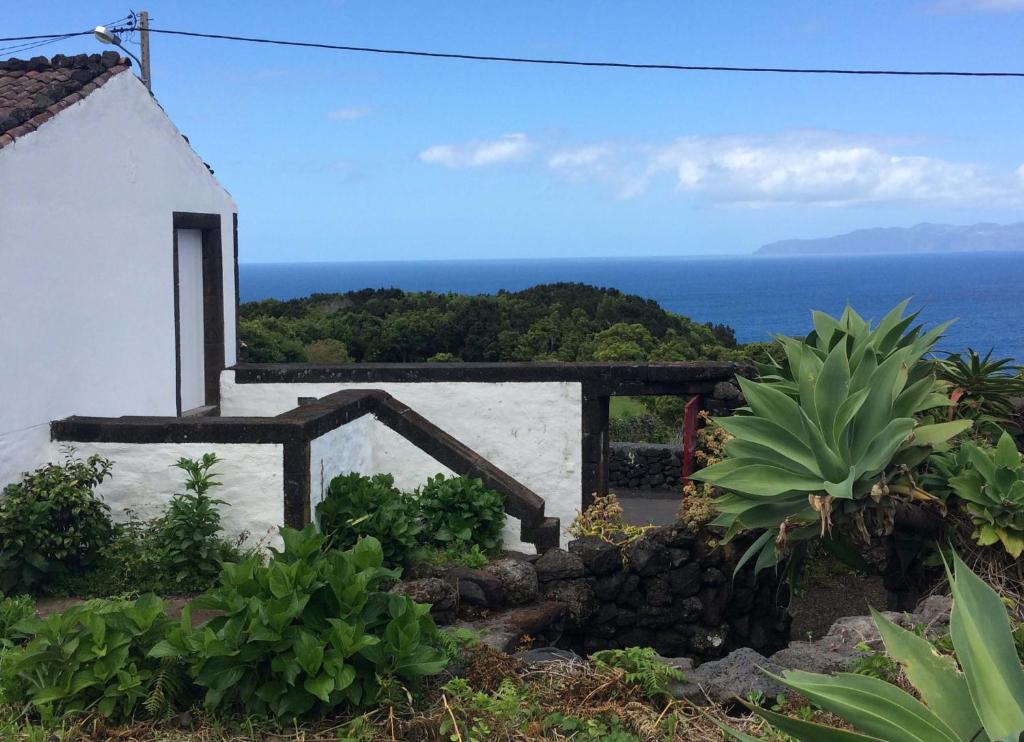 a white house with a view of the ocean at Casa do Ginjal in Santo Antonio