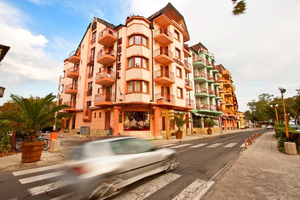 une voiture descendant dans une rue devant un bâtiment dans l'établissement Saint George Hotel & Medical Spa, à Pomorie