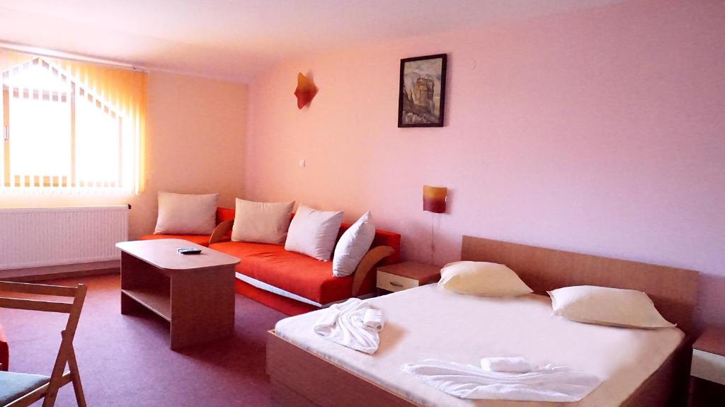 a living room with a bed and a couch at Hotel Restaurant Vodenitsata in Berkovitsa