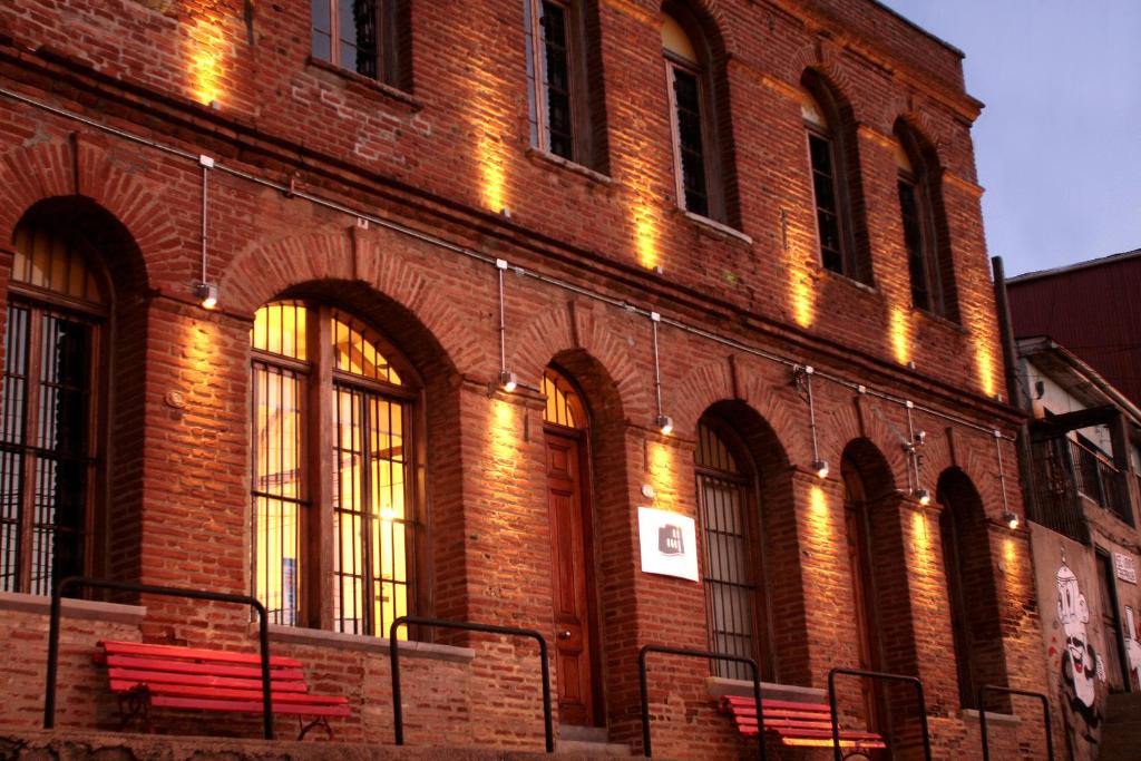 a brick building with benches in front of it at Hotel Ultramar in Valparaíso