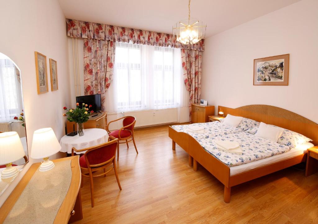 カルロヴィ・ヴァリにあるApartman Moravskaのベッドルーム1室(ベッド1台付)、ダイニングルームが備わります。