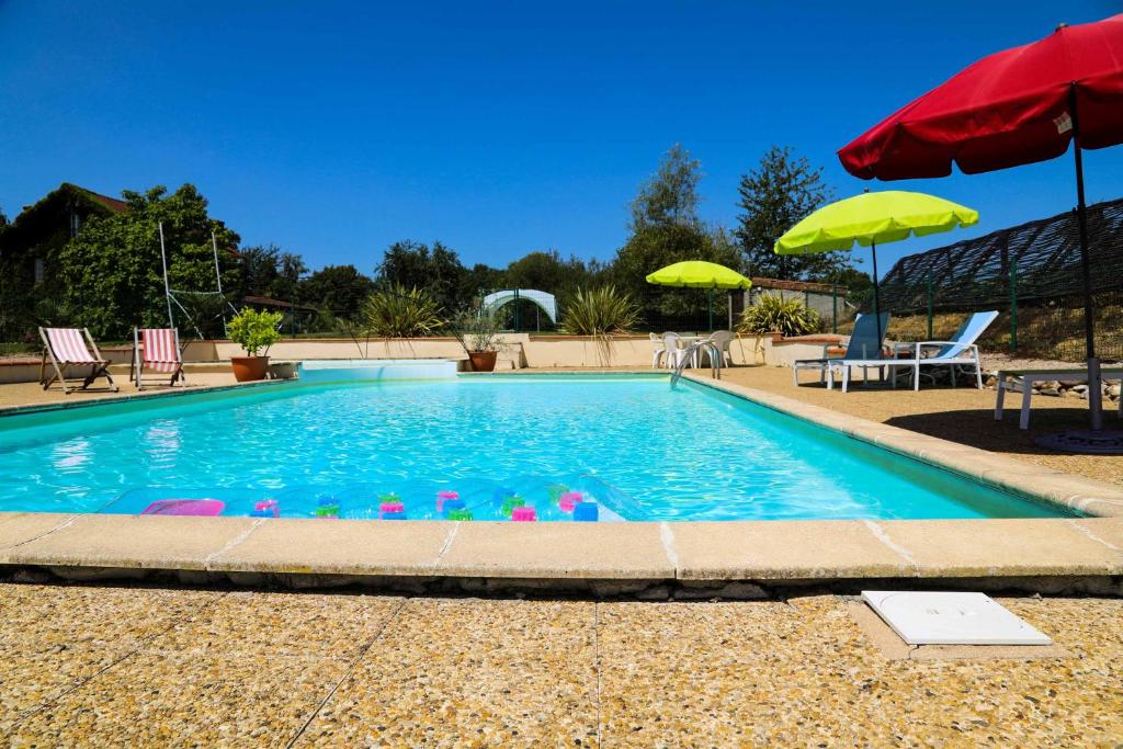 a swimming pool with chairs and umbrellas at Gites at Le Prielle in Madiran