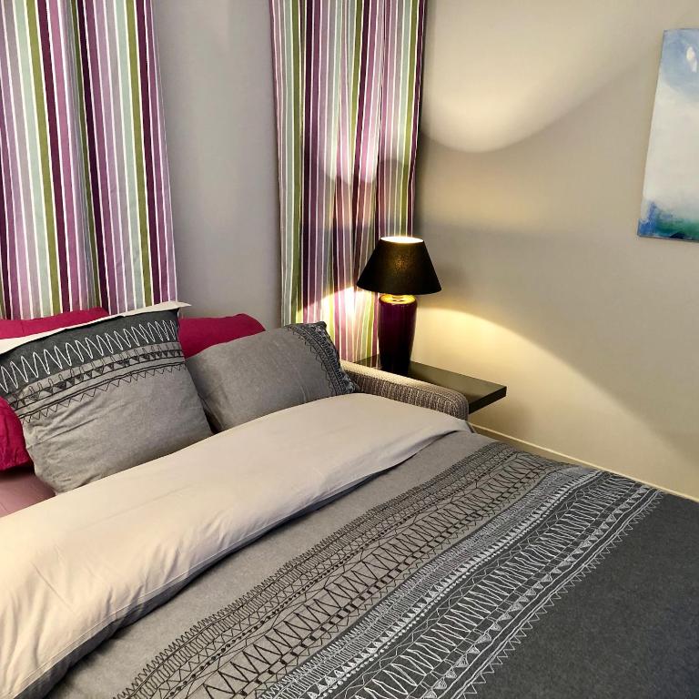 a bedroom with a bed with a striped curtain at Appartement Versailles quartier Notre Dame au pied du Chateau avec Parking in Versailles