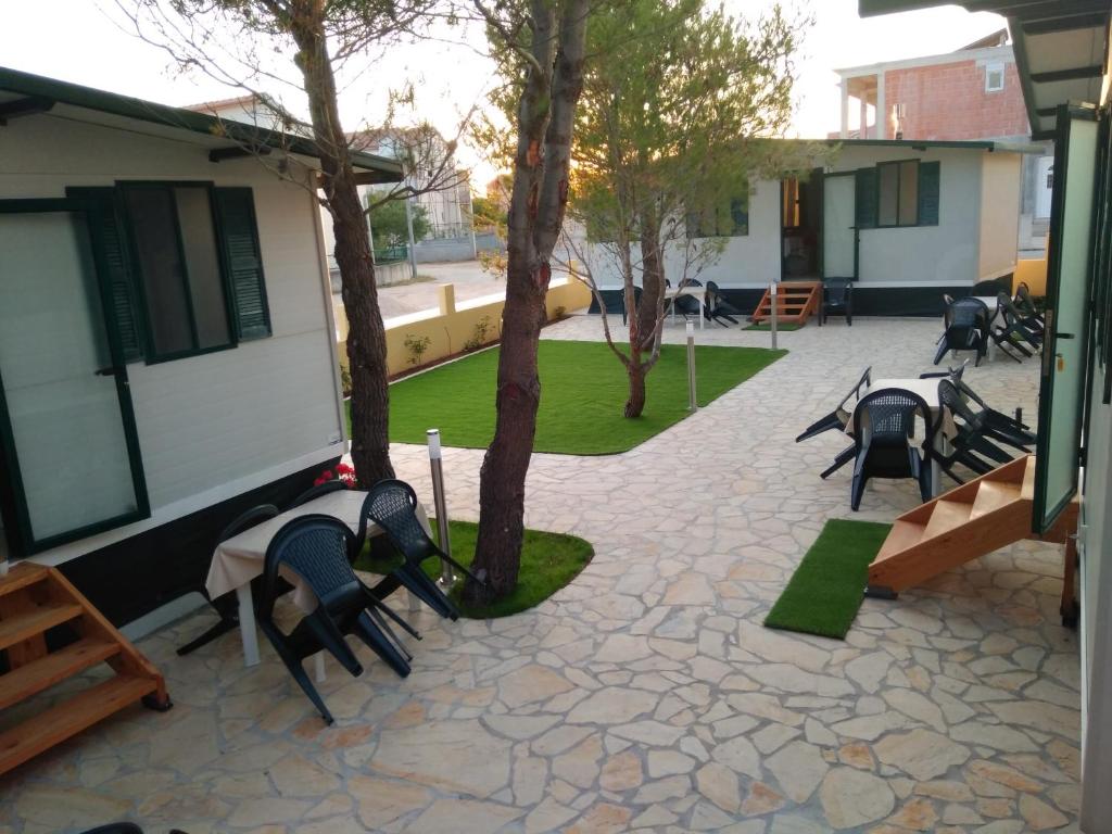 een groep stoelen en bomen op een patio bij Mobile homes Bonaca in Srima