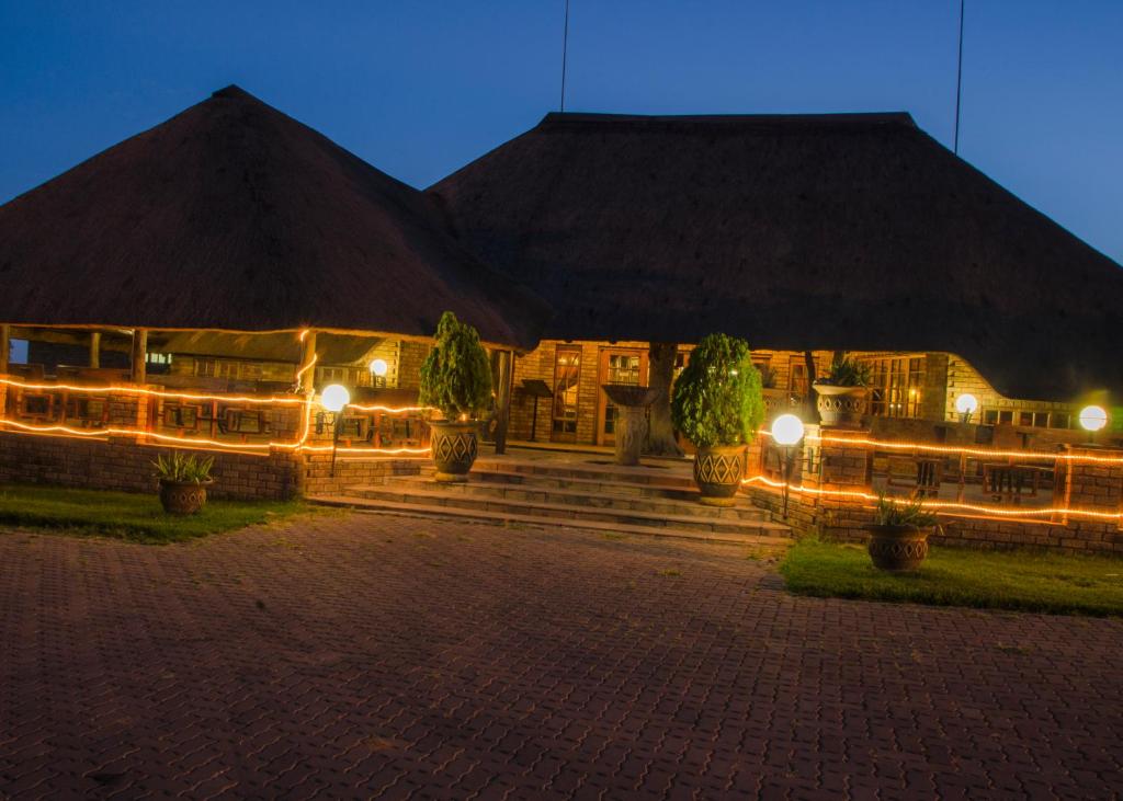 a night view of a building with lights at Pepe Piatto Lodge in Grootvlei