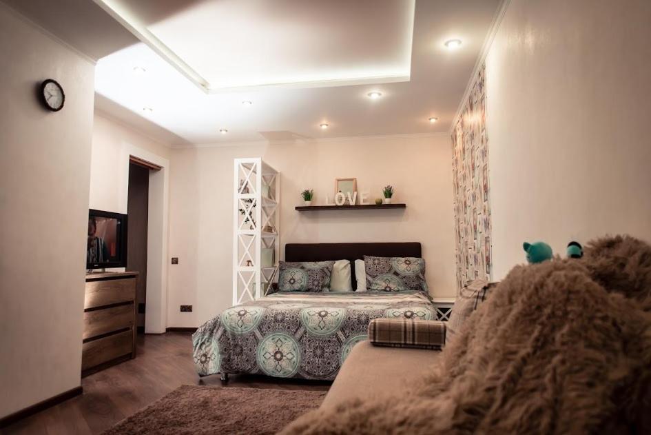 1 dormitorio con 1 cama y TV en Бирюзовый стиль, en Cherníhiv