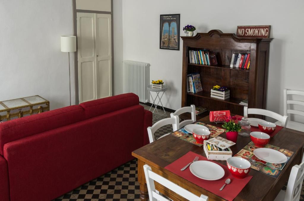 salon z czerwoną kanapą i stołem w obiekcie La Tintoria Suites w Asti